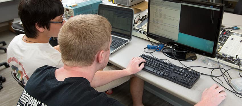 two students work on a computer